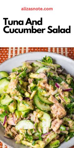 tuna and cucumber salad in a white bowl on top of a table cloth