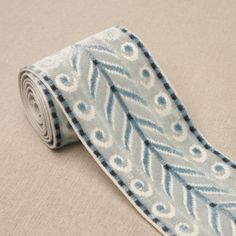 a tie with blue and white designs on it sitting on top of a beige surface