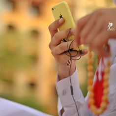 a woman is holding up her cell phone to take a selfie with ear buds