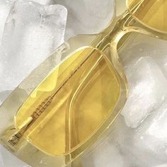 a pair of yellow sunglasses sitting on top of ice