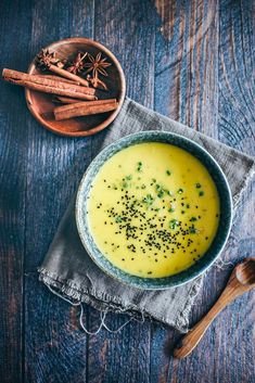 a bowl filled with soup next to cinnamon sticks