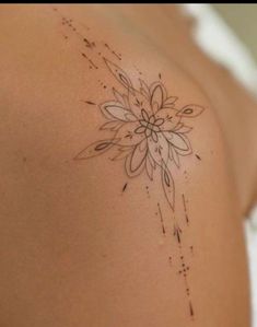 a woman's shoulder with a flower tattoo on her left arm and an arrow in the middle