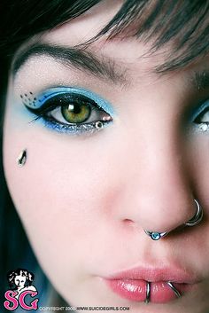 a woman with piercings on her face and nose