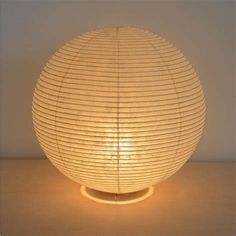 a lamp that is on top of a table with a light in the shape of a ball