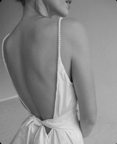 the back of a woman's dress with pearls on it