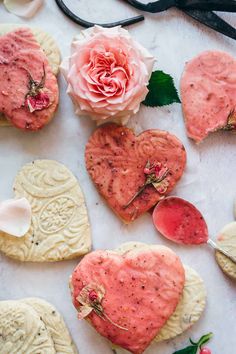 valentine's day cookies with flowers and scissors on the table next to each other