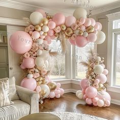 the balloon arch is decorated with pink, white and gold balloons