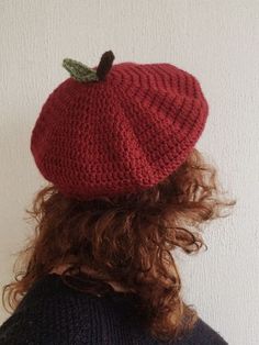 a person wearing a red knitted apple hat