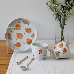 a table topped with plates and cups on top of a white cloth covered tablecloth