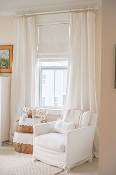 a white chair sitting in front of a window