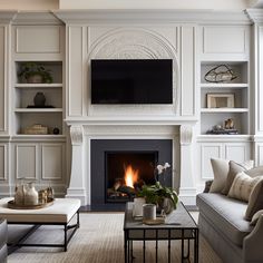 a living room filled with furniture and a flat screen tv mounted above a fire place