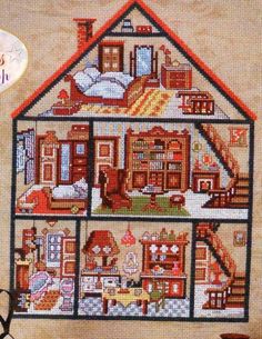 a cross - stitch house is shown in the shape of a doll's house