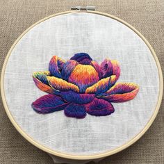 a colorful flower embroidered on a white piece of fabric