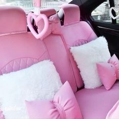 the interior of a car decorated in pink and white fur with heart shaped pillows on it