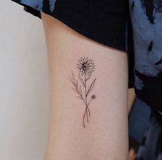 a small flower tattoo on the right side of the leg, with one single flower in it