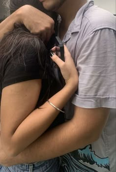 a man and woman embracing each other in front of a mirror