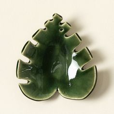 a green ceramic christmas tree ornament on a white wall