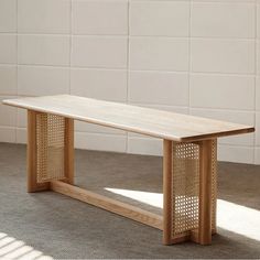 a wooden bench sitting on top of a carpeted floor next to a white brick wall