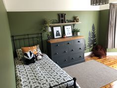 a bed room with a neatly made bed and dresser