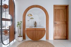 an oval mirror in the middle of a room next to a wooden cabinet and door