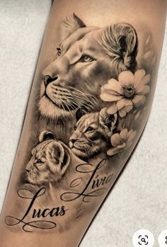 a lion and two cubs tattoo on the arm, with flowers around it's neck