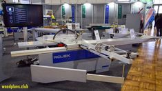 an automated conveyor belt in the middle of a room with people standing around it