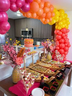 a table topped with lots of desserts and balloons