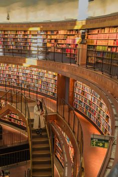 the interior of a public library with stairs and bookshelves