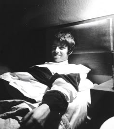 black and white photograph of a man laying in bed