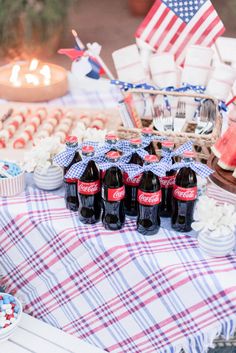 a table topped with lots of bottles of beer next to cupcakes and cakes