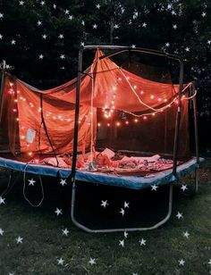 an outdoor trampoline with lights and stars on the ground