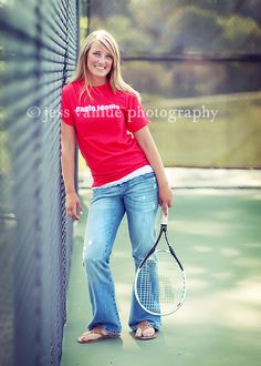 a young woman holding a tennis racquet on top of a tennis ball court