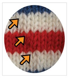 a red, white and blue crocheted button with arrows pointing to the right