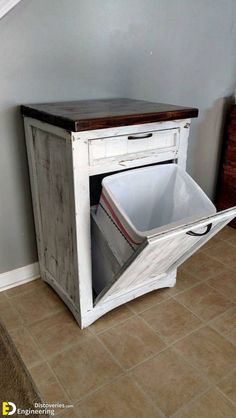 an old cabinet with a trash can in it