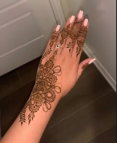 a woman's hand with henna tattoos on it