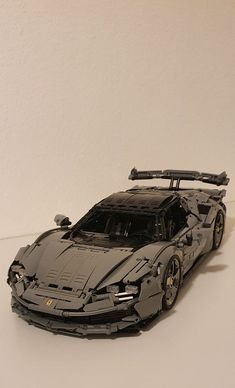 a lego model of a sports car on a white surface with no people around it