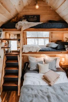 a loft bed with stairs leading up to the top floor and two beds on each side