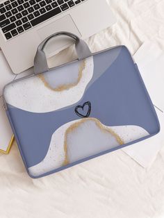 an open laptop computer sitting on top of a desk next to a blue and white bag