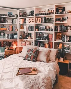 a bed sitting in front of a bookshelf filled with lots of books on top of it