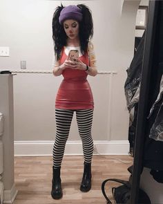 a woman is taking a selfie in the mirror with her cell phone while wearing tight black and white striped leggings