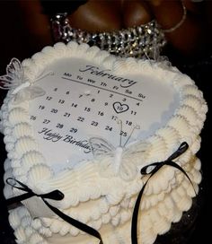 a white cake decorated with a date and butterfly on it's side, sitting on a table