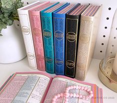 an open book sitting on top of a table next to a candle and some beads