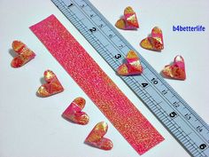 some pink and gold hearts are next to a ruler with other heart shapes on it