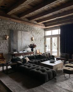 a living room filled with furniture and stone walls