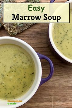 two white bowls filled with soup sitting on top of a wooden table next to crackers