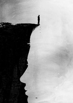 a man standing on the edge of a cliff with his head in the water looking down