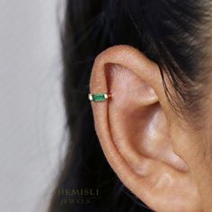 an ear with a single emerald stone in it's middle and the rest of its ear