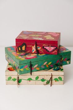 three wooden boxes are stacked on top of each other, one is decorated with flowers and butterflies