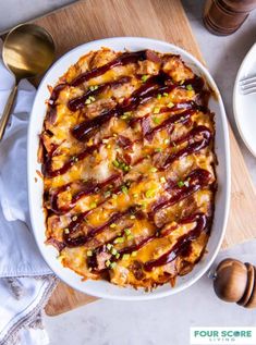 a casserole dish with bacon, cheese and green onions