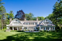 a large white house surrounded by trees and grass